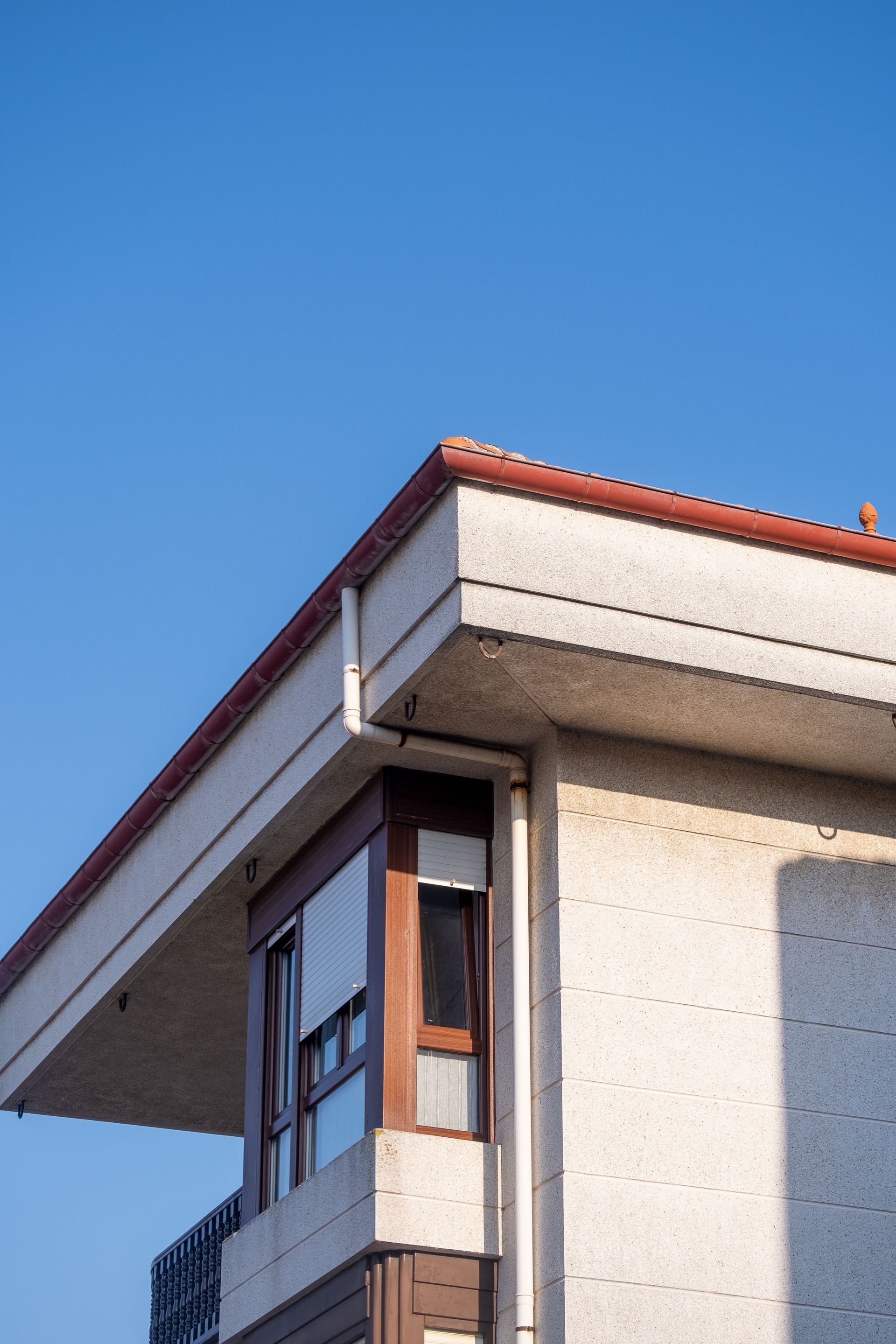 Bright, minimalist photo of a building facade under a clear blue sky.
